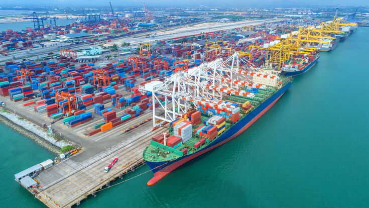 © Getty Images/iStockphoto container ship in import export and business logistic.By crane ,Trade Port , Shipping, cargo to harbor, Aerial view, Top view.